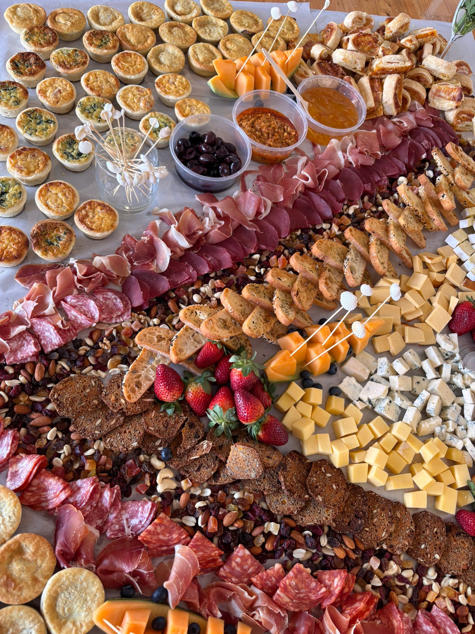An overhead view of a diverse catering spread with cheeses and meats
