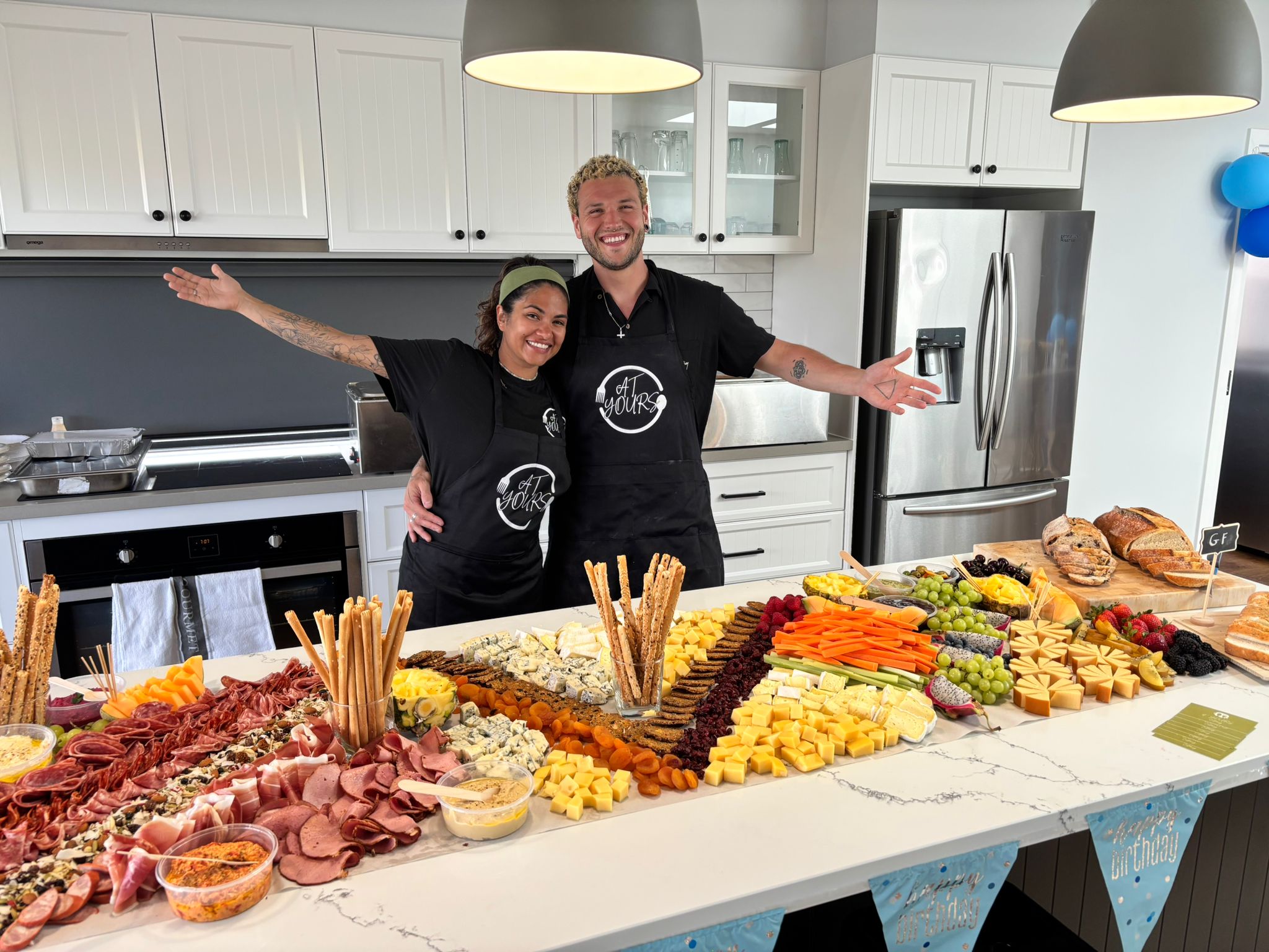 At Yours Catering staff posing with a large grazing board